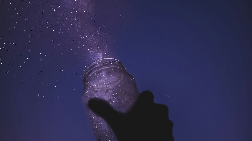 Throwing stardust from a glass jar into the sky