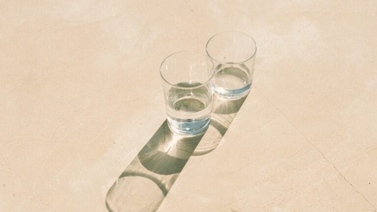 Two glasses of water sitting on a wall
