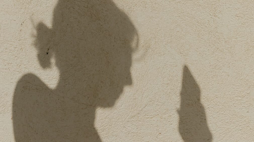 Shadow of a woman using a mobile phone