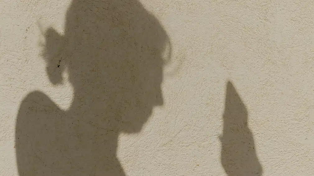 Shadow of a woman using a mobile phone
